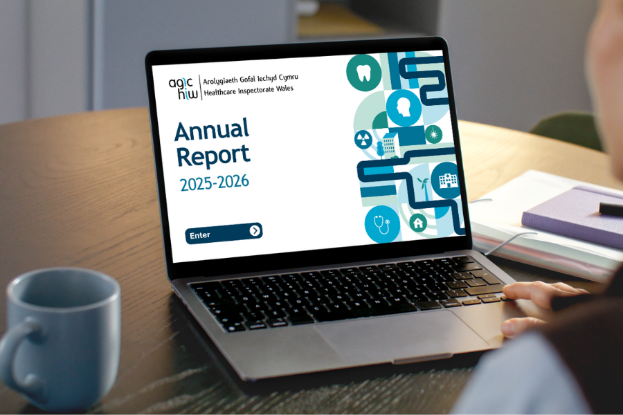 A woman reading HIW's Annual Report 2025-2026 on a laptop.